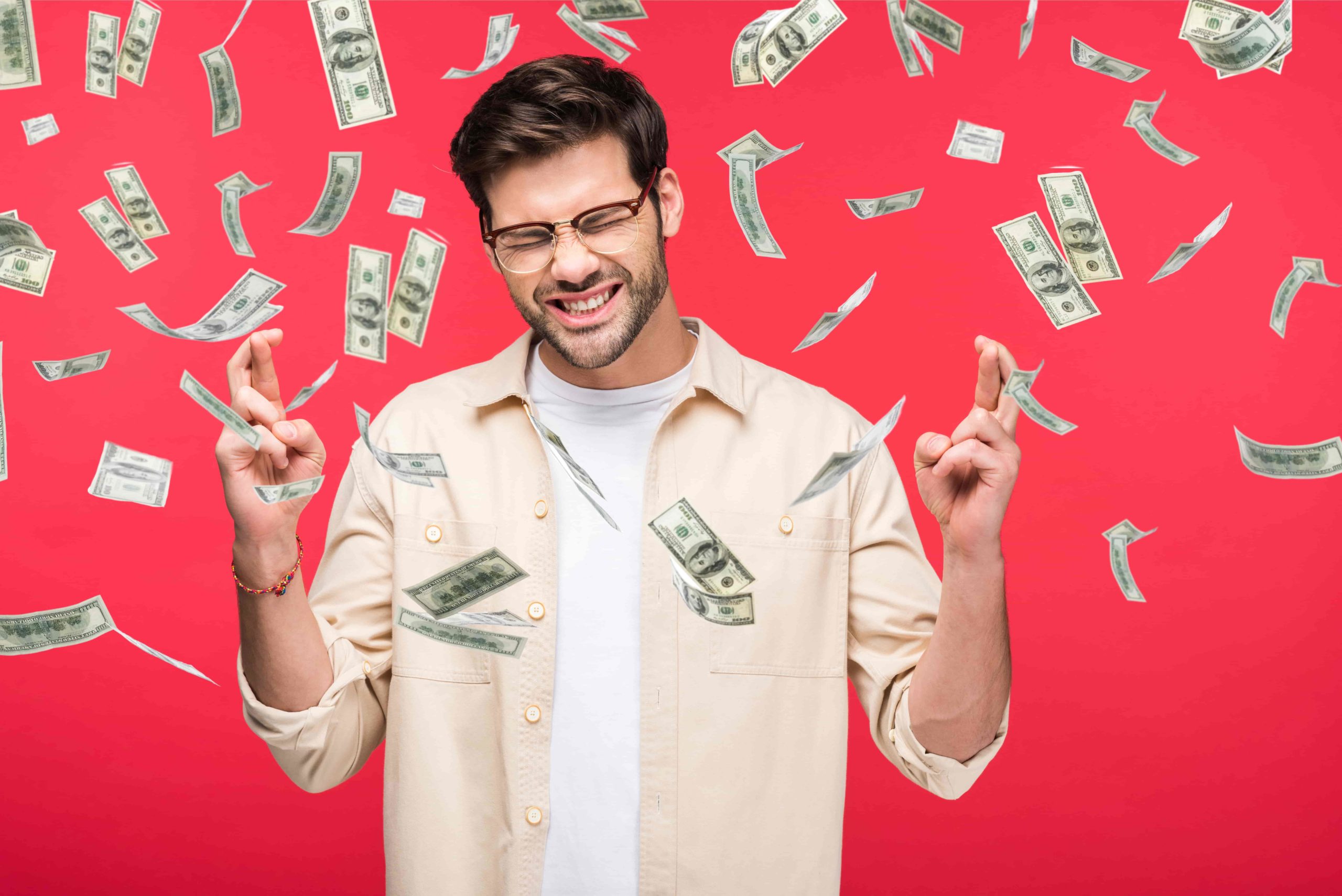 Man crossing fingers with money shower