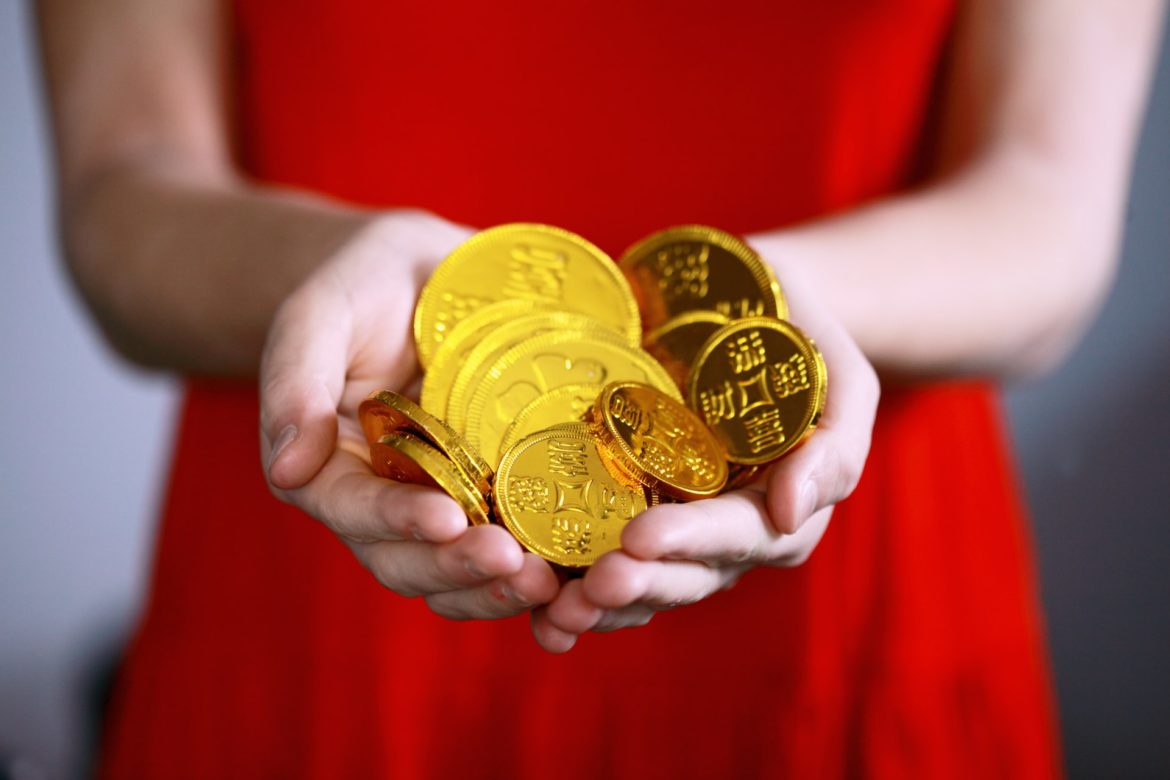 Mujer sosteniendo monedas de oro en su palma